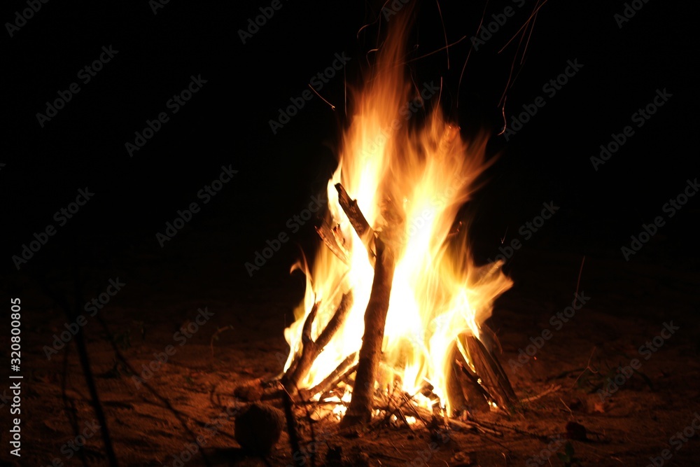 Wide shot of blazing flames from a bonfire, dark background Wide shot of blazing flames from a bonfire, dark background