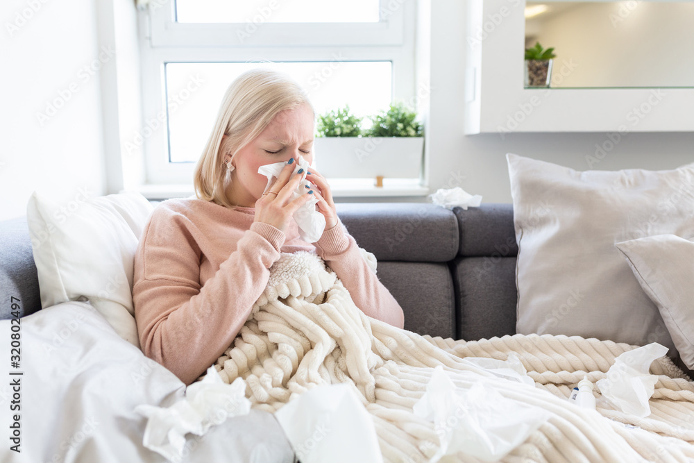 Sick Albino Woman.Flu.Woman Caught Cold. Sneezing into Tissue. Headache. Virus .Medicines. Young Woman Infected With Cold Blowing Her Nose In Handkerchief. Sick woman with a headache sitting on a sofa Sick Albino Woman.Flu.Woman Caught Cold. Sneezing into Tissue. Headache. Virus .Medicines. Young Woman Infected With Cold Blowing Her Nose In Handkerchief. Sick woman with a headache sitting on a sofa