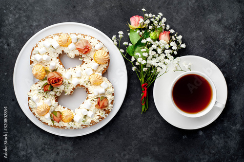 tea and cake in the form of 8 is decorated with flowers, cream cheese, marshmallows, Bizet on a stone background. romantic delicious breakfast on International Women's Day March 8