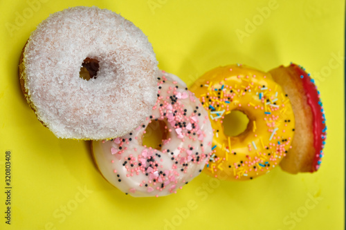 multicolored donuts on a yellow background, space for text