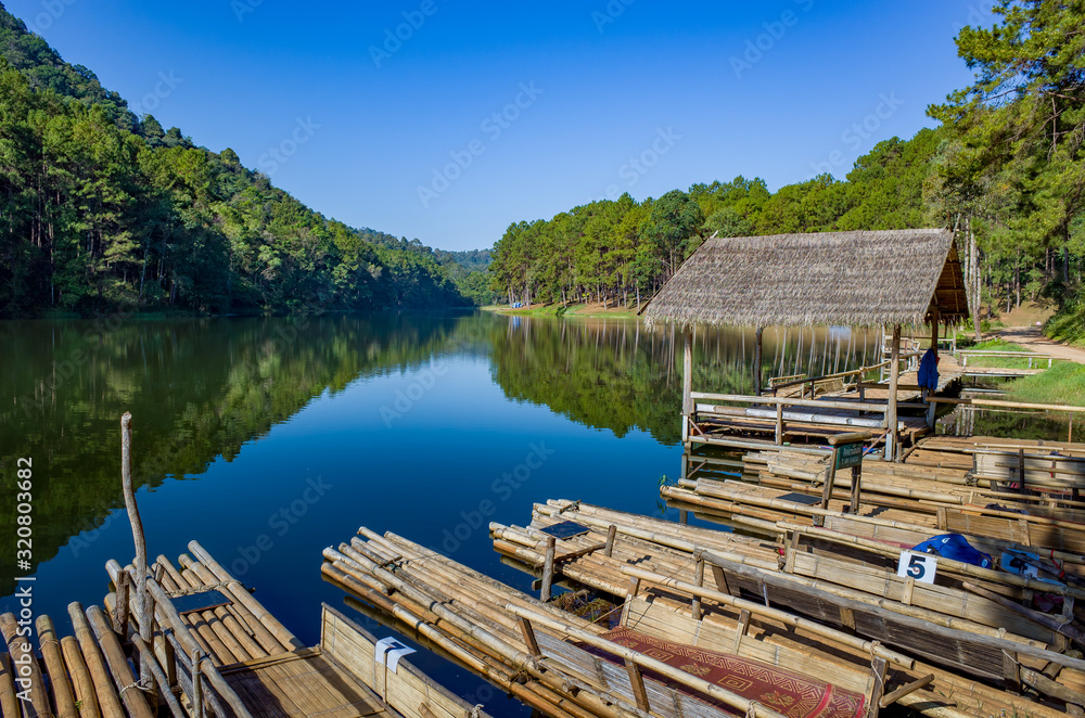 Naklejka premium Pang Oung Roum Lake, Clear water wir reflection and trees, north of Thailand, Bamboo raft for sightseeing