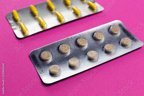 capsules and pills on a pink background