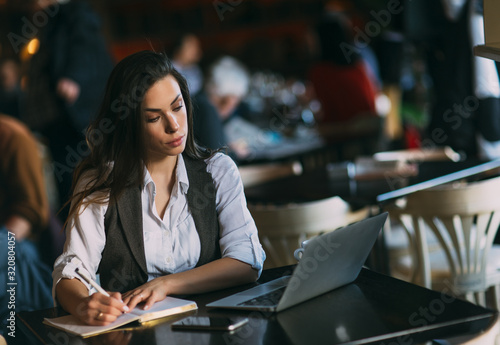 Young beautiful woman preparing for exams, surfing articles about innovations in web development. Learning and business concept