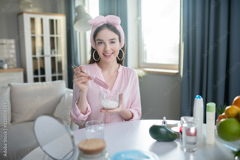 Smiling pretty girl in a pink headband holding a bowl in her hands Smiling pretty girl in a pink headband holding a bowl in her hands