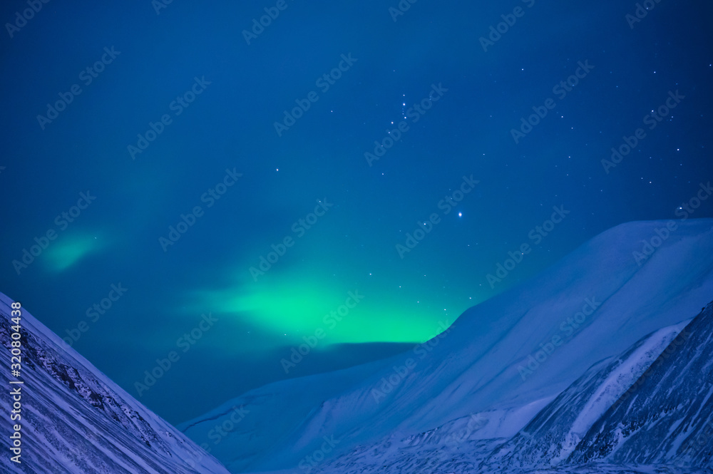 The polar arctic Northern lights aurora borealis sky star in Norway Svalbard in Longyearbyen  with the  mountains. Travel adventure