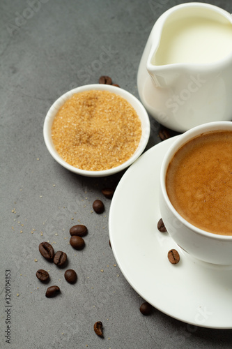 black coffee in a white cup, milk and brown sugar close-up