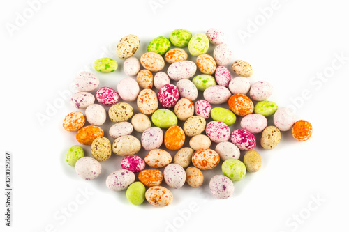 colored sweet candy peanuts in icing, similar to bird eggs on a white background