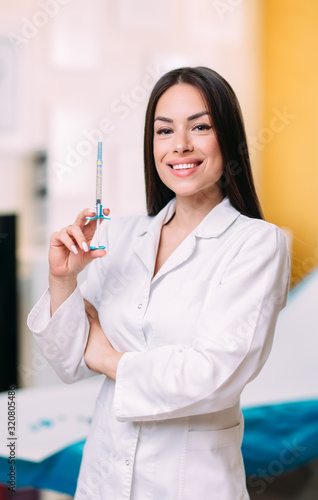 Portrait of smiling female doctor wearing white coat in hospital office