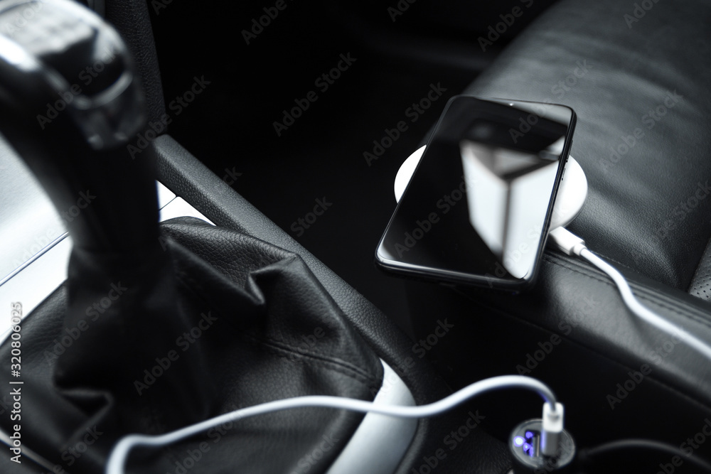 Mobile phone, smartphone charge battery, wireless charging in the car plug close up Mobile phone, smartphone charge battery, wireless charging in the car plug close up