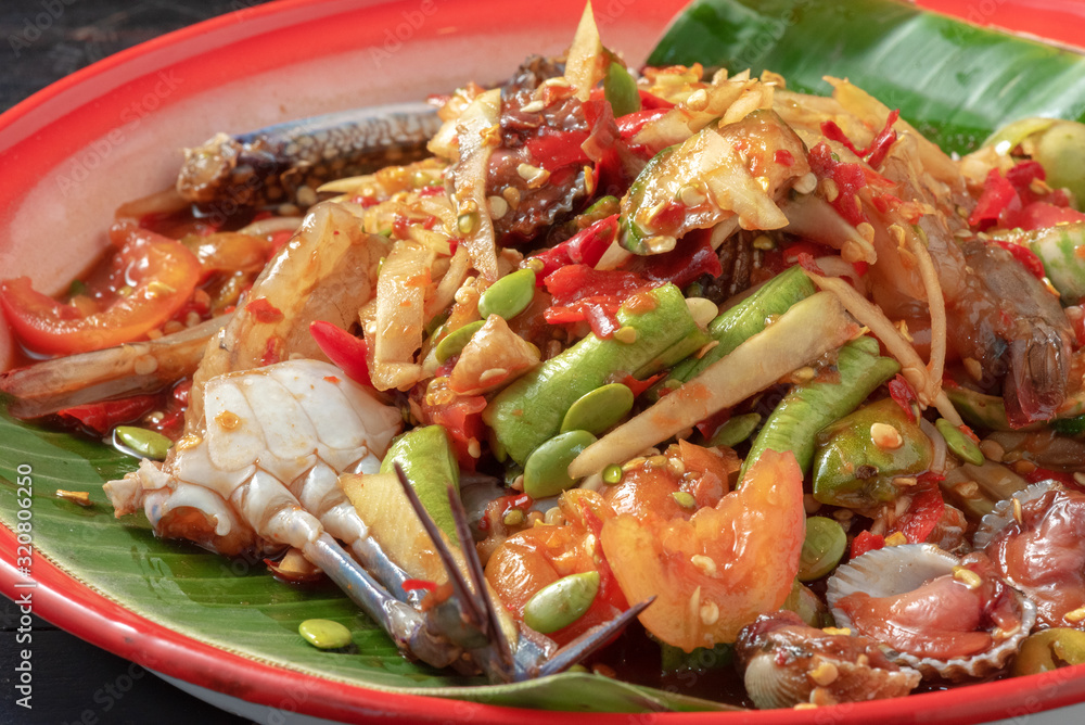 thai seafood salad mixed with Papaya, chopped on colorful tray thai seafood salad mixed with Papaya, chopped on colorful tray