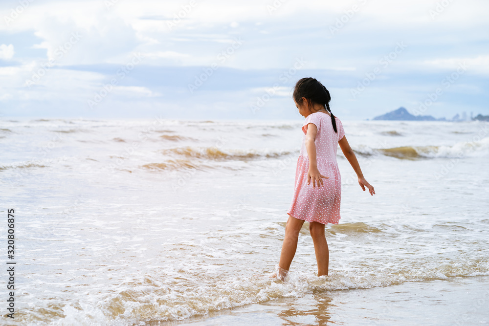 Happy little children girl playing on the beach at the day time. Happy little children girl playing on the beach at the day time.