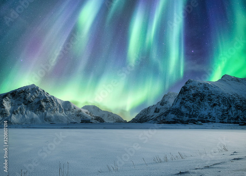 Foto Aurora Borealis, Northern Lights Above on snowy mountain in Skagsanden Beach at