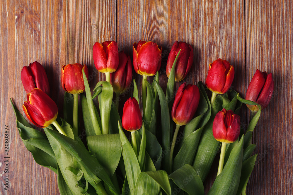 Fresh red tulips on a wooden background on Valentine's Day, mother's Day. Top view