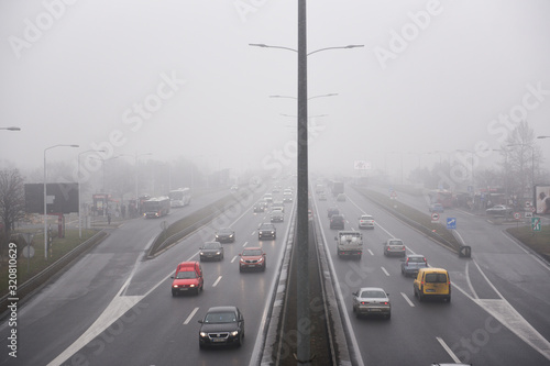 BELGRADE, SERBIA - 16 JANUARY 2020: Cars driving on a highway as heavy fog dominate the sky over the Serbian capital. A thick cloud of pollution has been visible over the city for several days