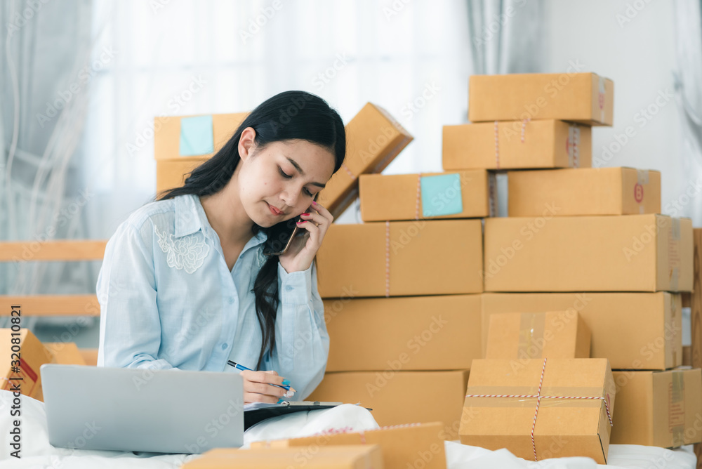 Young woman entrepreneur selling online product and use laptop in her workplace. Young woman entrepreneur selling online product and use laptop in her workplace.
