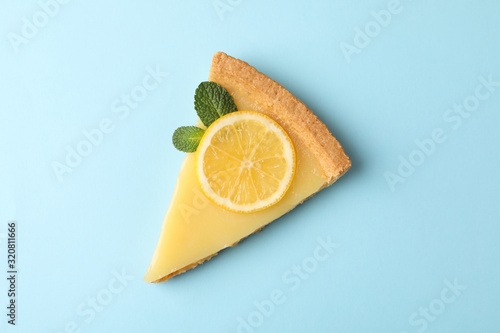 Lemon tart slice on blue background, top view