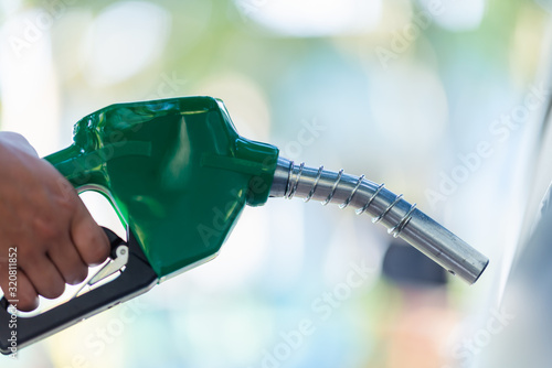 Foto Man Handle pumping gasoline fuel nozzle to refuel