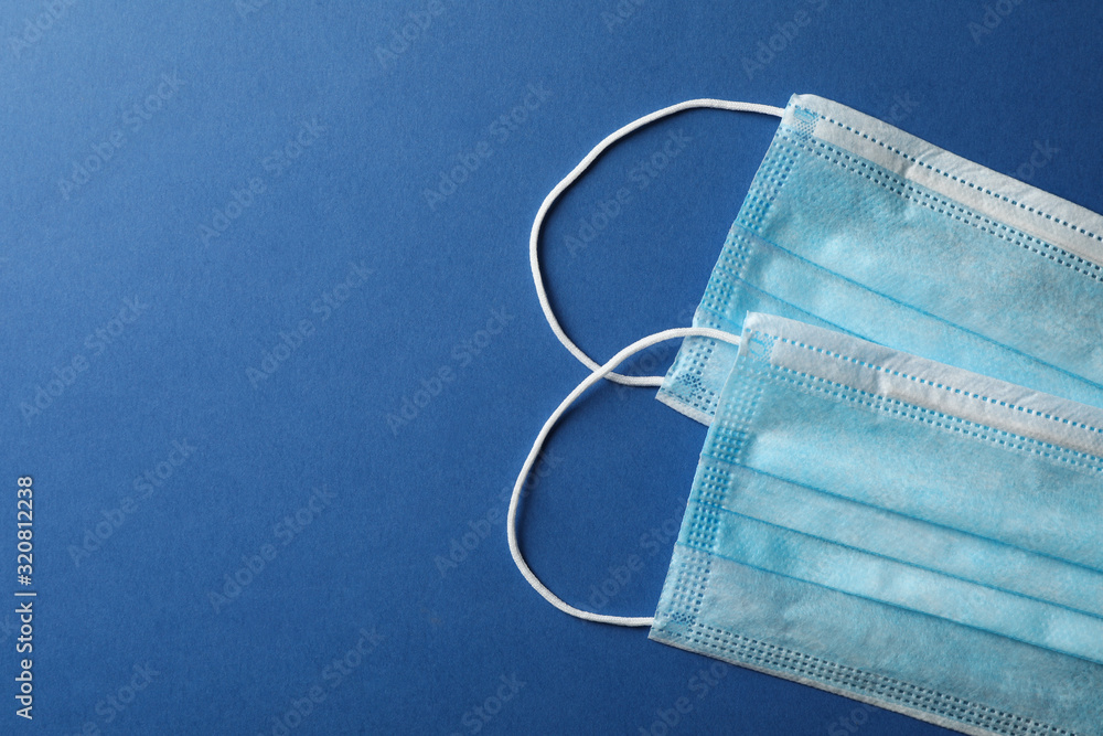 Protective mask on blue background, top view, space for text.Virus protection. Healthcare and medical concept Protective mask on blue background, top view, space for text.Virus protection. Healthcare and medical concept