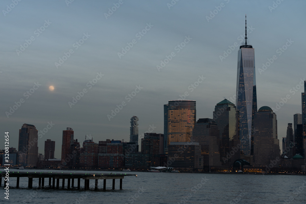 Obraz premium Lower Manhattan New York City Skyline seen from the Jersey City Waterfront with a Helipad during the Early Evening