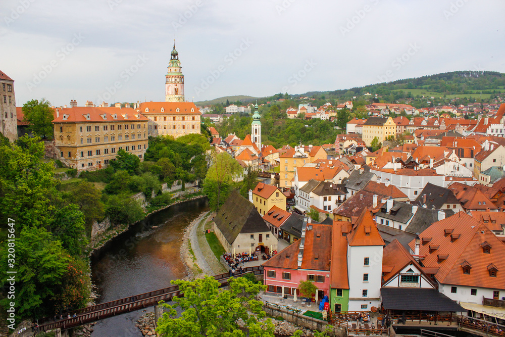 Panoramic view of the Castle Tower in State Castle, the most famous symbol of Cesky Krumlov, and St. Jost Church, with colorful houses on the right (Czech Republic)