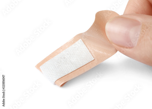 Woman putting sticking plaster on white background. First aid item
