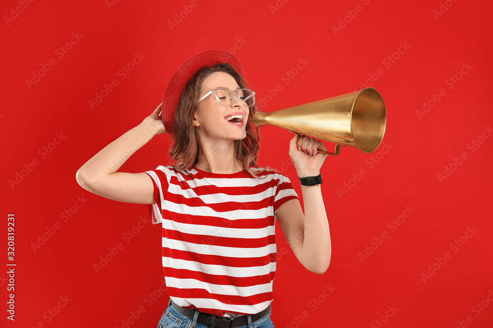 Naklejka premium Young woman with megaphone on red background