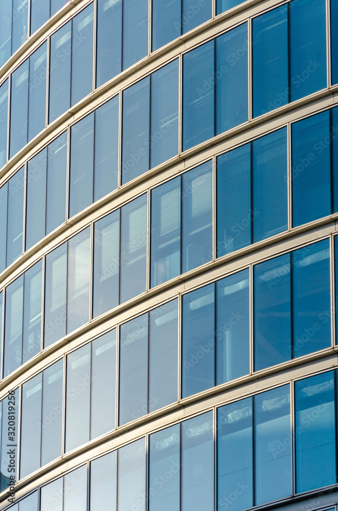 Close up view of detail on a modern glass building with reflective glass and contemporary design. Close up view of detail on a modern glass building with reflective glass and contemporary design.