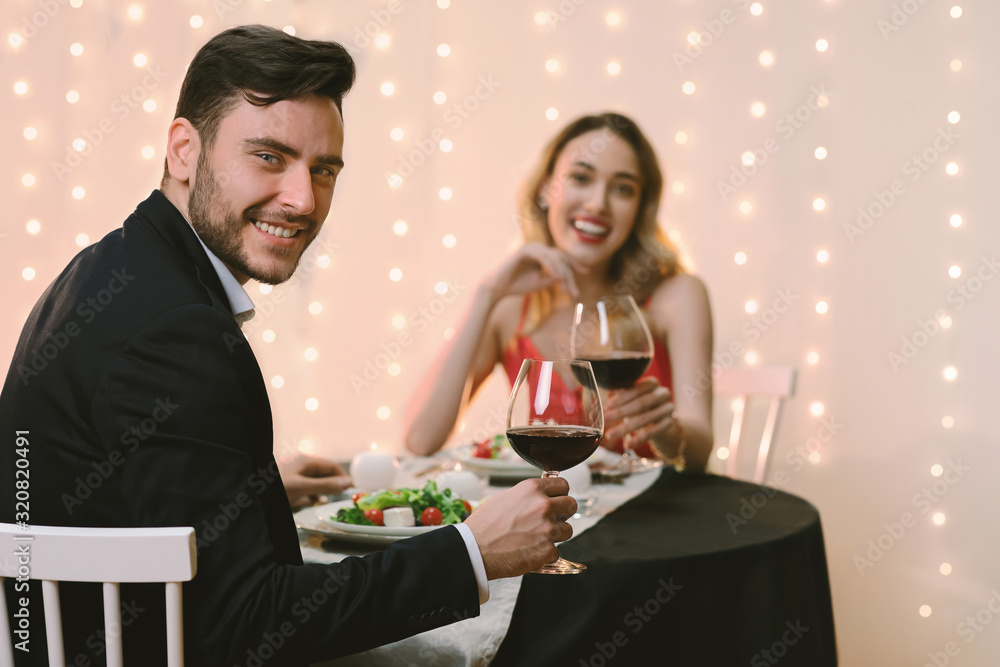 Romantic couple with glasses of red wine on date in restaurant Romantic couple with glasses of red wine on date in restaurant