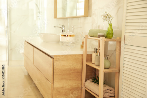Shelving unit with toiletries in stylish bathroom interior