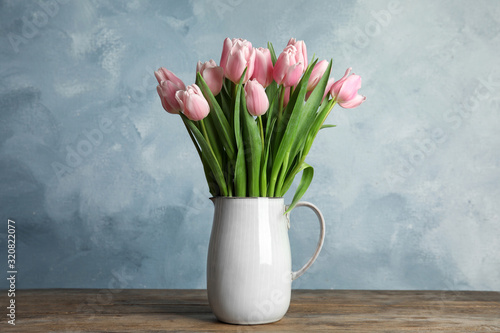 Beautiful pink spring tulips in vase on wooden table #320822077