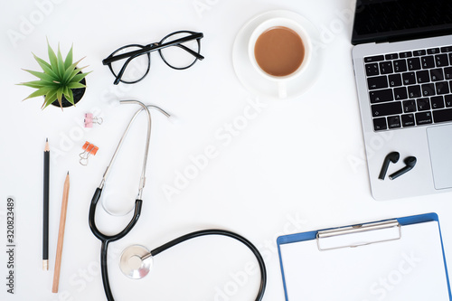 Work space medical technology and healthy concept on modern white table desk background with stethoscope of doctor and laptop computer, supplies, Top view with copy space, Flat lay