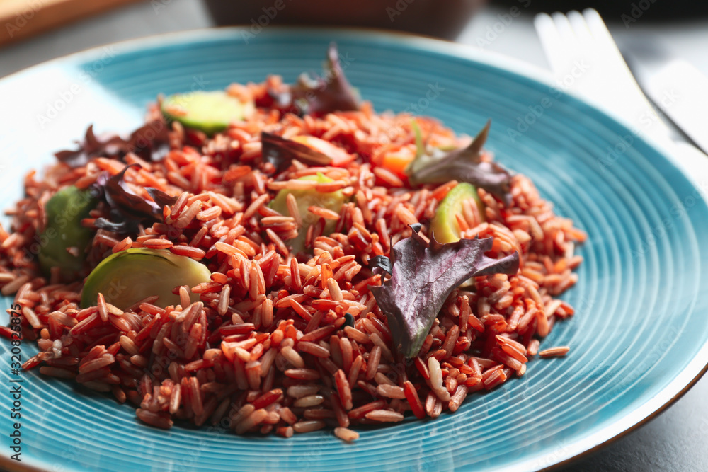Tasty brown rice with vegetables on table, closeup Tasty brown rice with vegetables on table, closeup