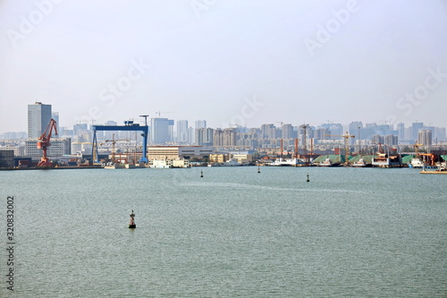 Panoramic views of piers, sea vessels, tugboats and the city of Rizhao, China. photo