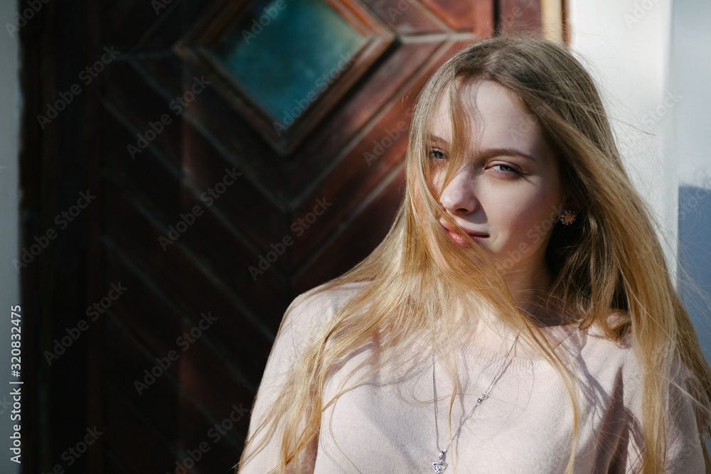 Fototapeta premium Lifestyle portrait of a beautiful blonde white girl ouside in natural light during daytime