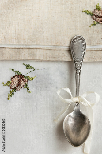 Vintage russian silverspoon with silk ribbon on linen napkin. Old fashion heroloom silverware photo