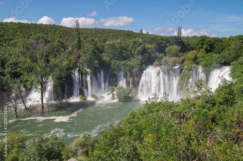 Beautiful view of Kravica waterfalls after heavy rains. Large tufa cascade on Trebizat River  in karstic heartland of Herzegovina. Lush surrounding and rich riparian ecosystem. Bosnia and Herzegovina