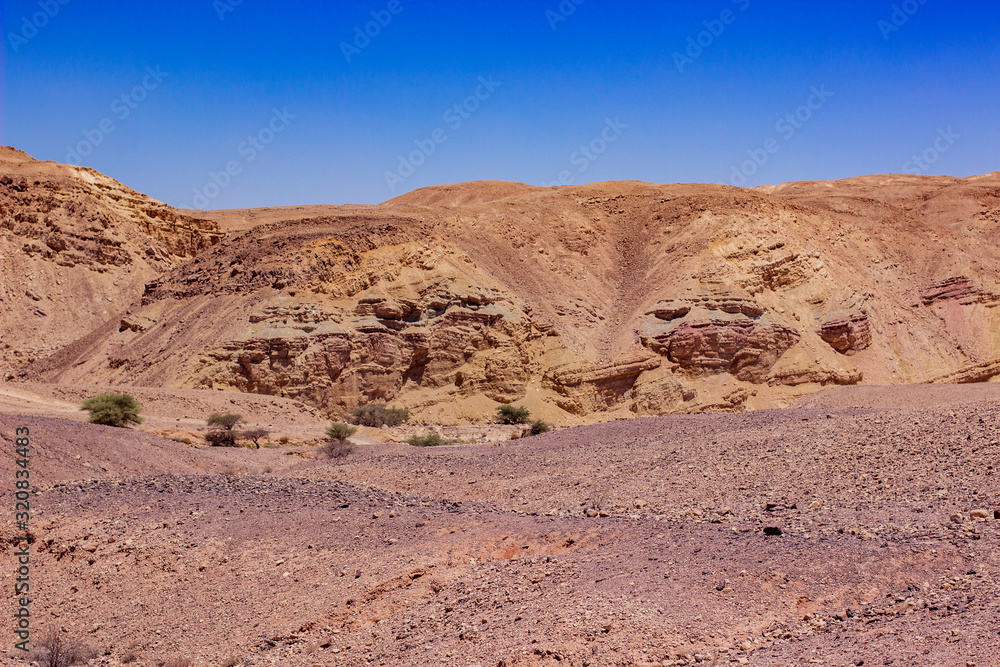 desert landscape dry wasteland scenic environment view valley and sand stone rocky mountain ridge horizon background vivid blue sky copy space for text here
