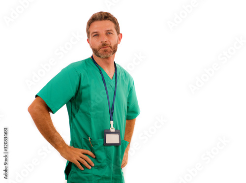 attractive and successful physician man posing confident for hospital staff corporate portrait in green medical uniform isolated on white background in health care