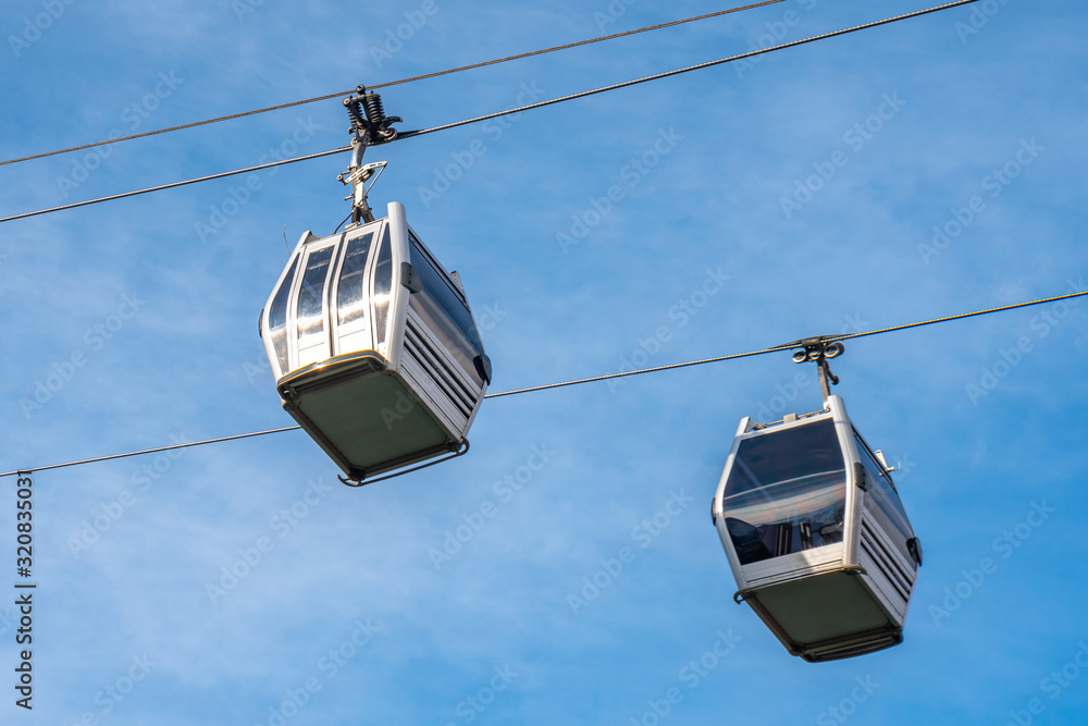 View of cableway gondola cable car on blue sky background View of cableway gondola cable car on blue sky background