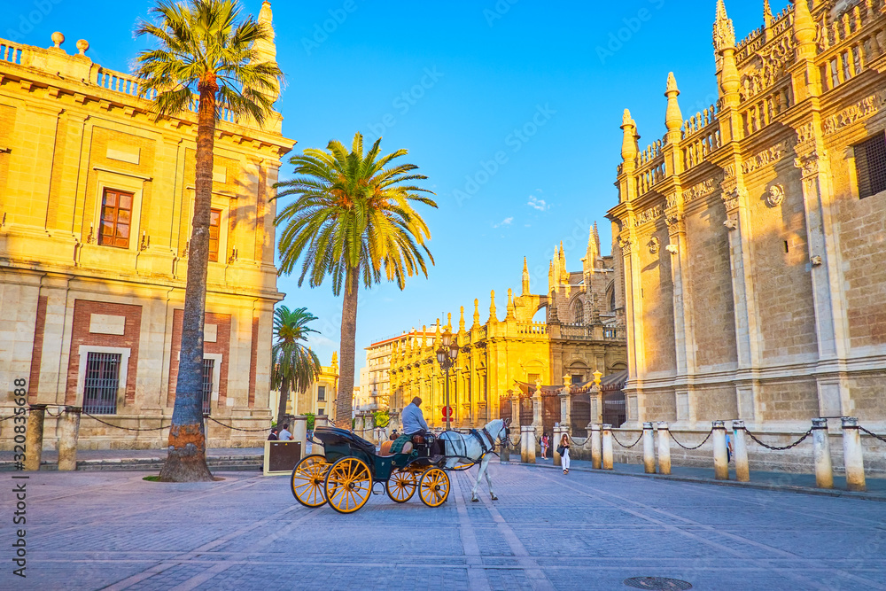 Fototapeta premium The tourist carriage rides in old town of Seville, Spain
