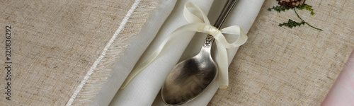 Fotografie Vintage russian silverspoon with silk ribbon on linen napkin