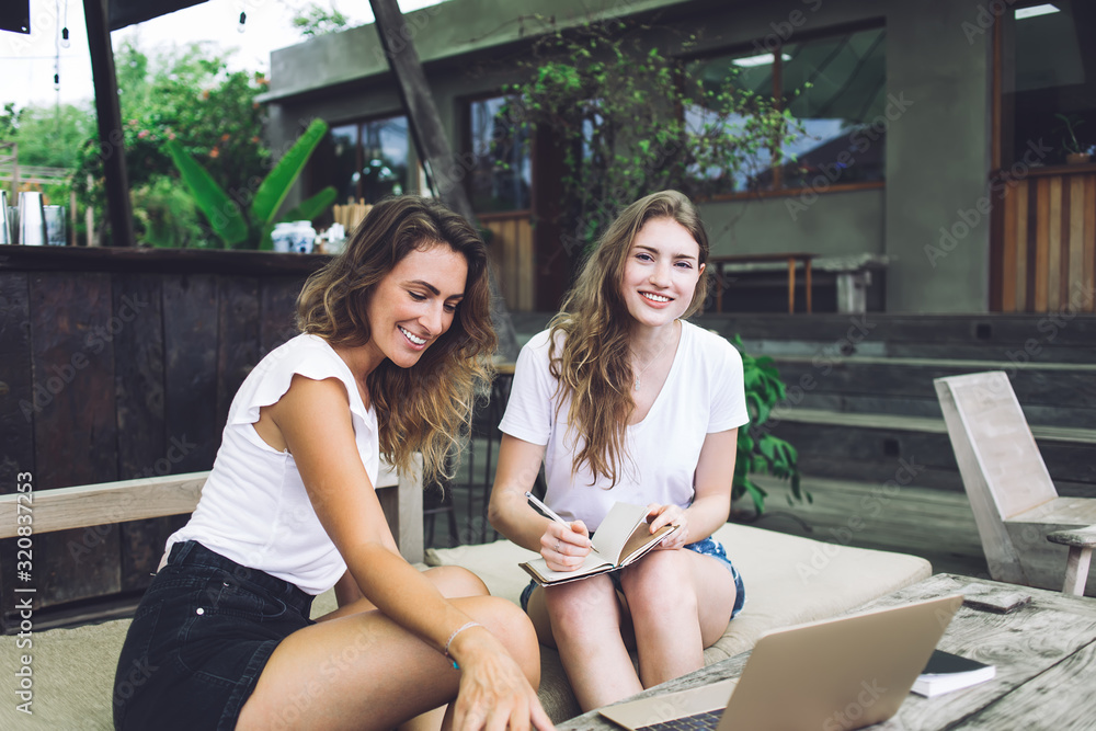 Smiling woman studying with friend in cafe Smiling woman studying with friend in cafe