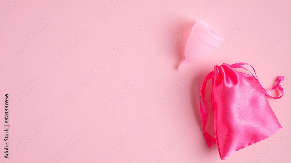 Menstrual cup with case on pink background. Top view with copy space. Alternative feminine hygiene product. Women health care concept. Menstrual cup with case on pink background. Top view with copy space. Alternative feminine hygiene product. Women health care concept.