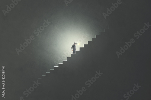 man with lamp rising stairs in the darkness photo
