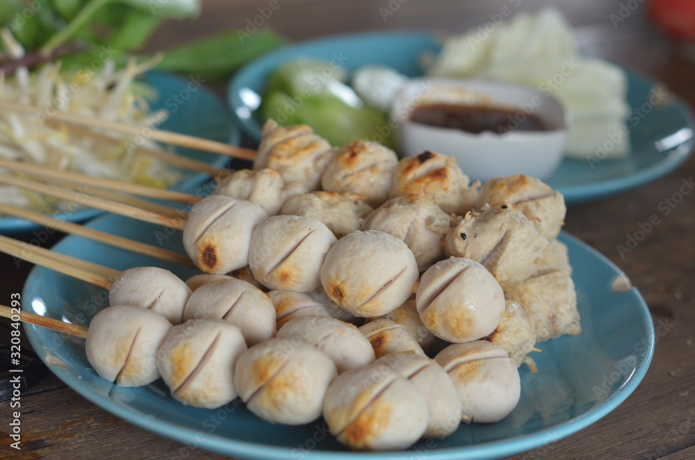 Many wooden meatballs on a blue plate Many wooden meatballs on a blue plate