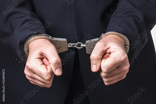 Bilde på lerret A man in a suit and handcuffs, close-up. Arrest Concept