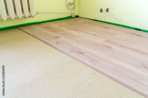 Laying floor panels on chipboard sleepers in the room.