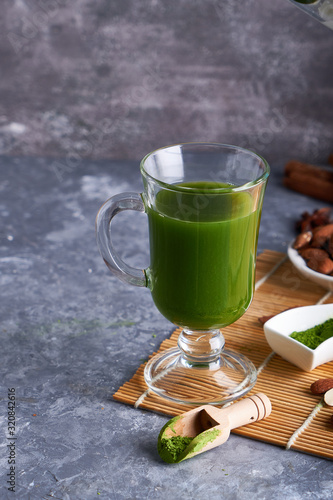 Green tea Matcha in glass on gray stone background