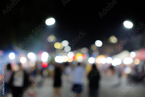Blurred image of people in day market festival in city park background © กรบุรษ วรดี