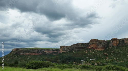 Moluti sandstone cliffs at the border of Lesotho in South Africa at the Camelroc travel guest farm, stunning clouds, most amazing mountains and green scenery landscapes photo